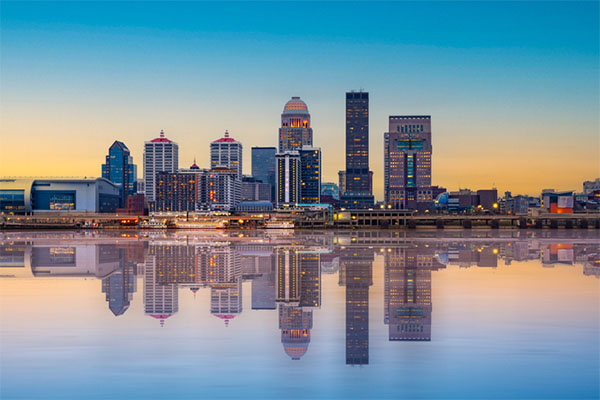 City skyline of Louisville, Kentucky shows its many skyscrapers reflected in the water below.