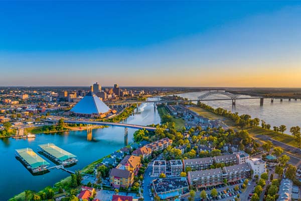 Wide angle view of the Memphis, Tennessee skyline shows it many bridges across the river, landmark Memphis Pyramid, and buildings.