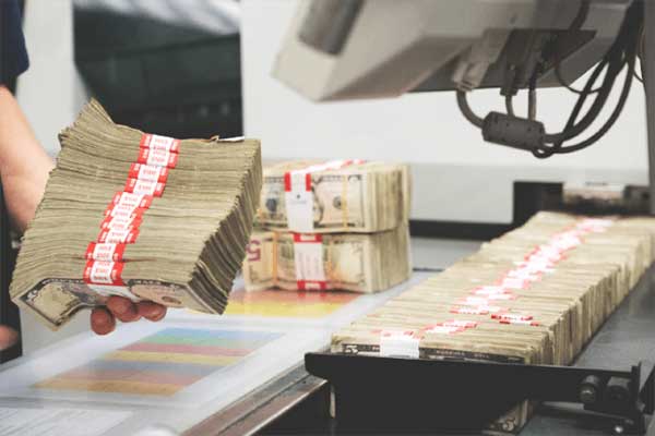 Stacks of U.S. currency grouped by red and white bands.